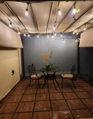 a dining room with a table and chairs and lights at Encantadora Casa Familiar en Santiago in Santiago de los Caballeros