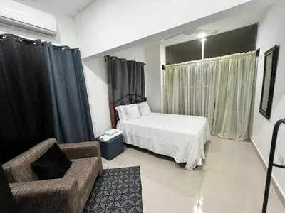 a bedroom with a bed and a chair and a couch at The Omelís House in Santa Bárbara de Samaná