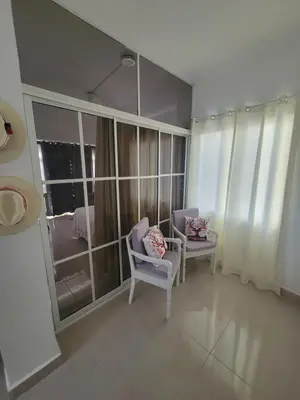 a living room with two chairs and a large window at The Omelís House in Santa Bárbara de Samaná