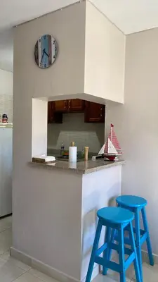 two blue stools sitting at a kitchen counter with a clock at Apartamento en Proyecto Frente al Mar en Sosua in Los Altos de Jalisco