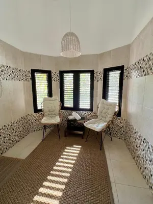 a room with two chairs and a table and windows at Villa Marina in Sosúa