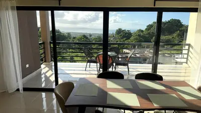 a dining room with a table and chairs on a balcony at Casa Vista Mar in Río San Juan