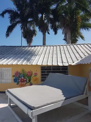 a bed in front of a building with a roof at Finca im Grünen, sehr ruhige Lage, Terrasse mit Pool in Baní
