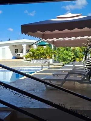 a pool with a table and an umbrella and chairs at aparthotel las taranas in Villa Riva