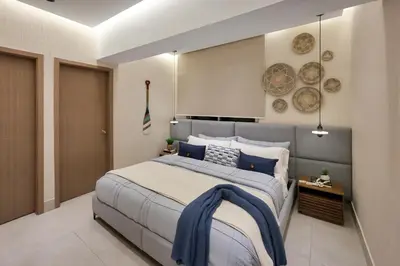 a bedroom with a large bed with blue pillows at Lujoso Penthouse frente a la Playa de Boca Chica in Boca Chica