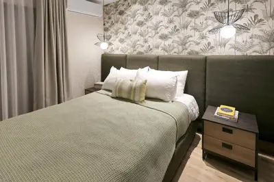 a bedroom with a bed and a wall with a wallpaper at Lujoso Penthouse frente a la Playa de Boca Chica in Boca Chica