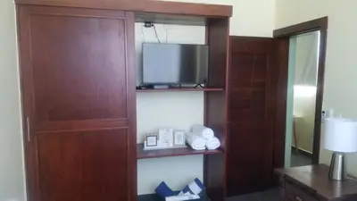 a room with a tv and a wooden entertainment center at My Deligth in San Felipe de Puerto Plata
