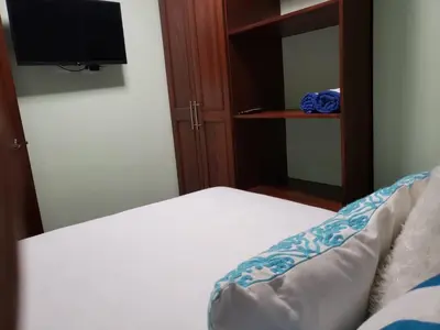 a bedroom with a bed and a tv and a mirror at My Deligth in San Felipe de Puerto Plata