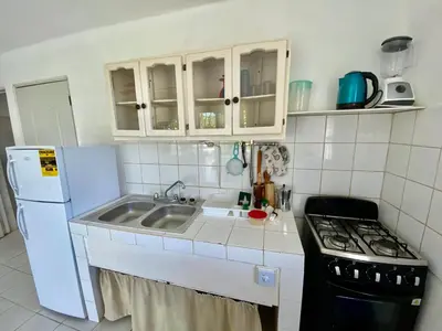 a small kitchen with a sink and a refrigerator at Casa Blanca Samaná - Las Galeras in Las Galeras
