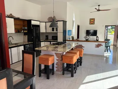 a kitchen with a large island with bar stools at Okaina 7 Penthouse in Cabarete