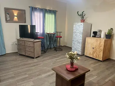 a living room with a flat screen tv and a table at Hostal Bless house in San Pedro de Macorís