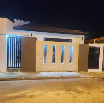 a building with two doors and a gate at night at Mila's House in La Romana