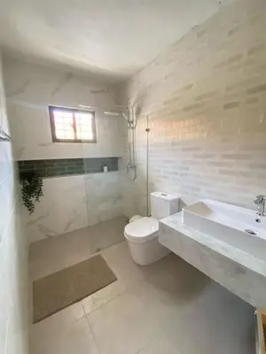 a white bathroom with a toilet and a sink at Mila's House in La Romana