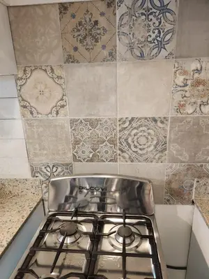 a stove top oven in a kitchen with tiles at Mila's House in La Romana