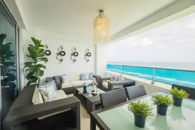 a living room with a couch and tables and a pool at Luxury Beachfront 2BR at Las Olas, Juan Dolio in La Puntica de Juan Dolio