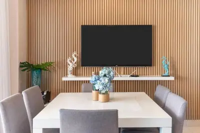 a dining room with a table with chairs and a tv at Luxury Beachfront 2BR at Las Olas, Juan Dolio in La Puntica de Juan Dolio