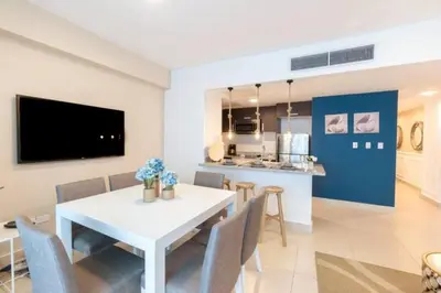 a dining room and kitchen with a white table and chairs at Luxury Beachfront 2BR at Las Olas, Juan Dolio in La Puntica de Juan Dolio