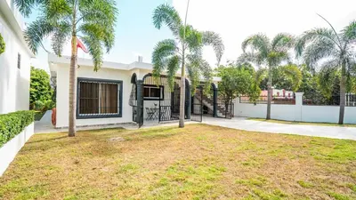 a house with a yard with palm trees at Ketsys Home Near Santo Cerro in Concepción de La Vega