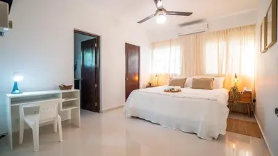 a white bedroom with a bed and a desk at Ketsys Home Near Santo Cerro in Concepción de La Vega