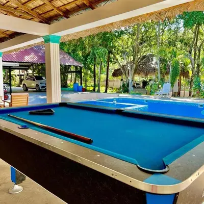 a pool table in front of a swimming pool at Villa Jarabacoa in Concepción de La Vega