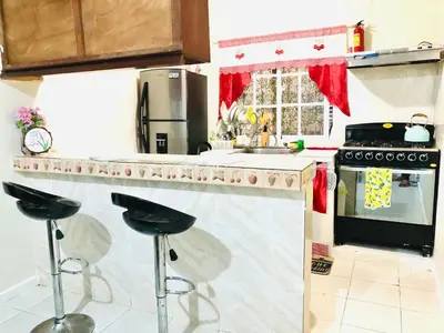 a kitchen with a counter with two stools in it at La casa del almendro in Concepción de La Vega