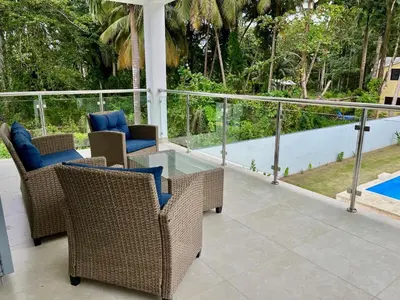 a patio with wicker chairs and a swimming pool at Villa Valentina Cabarete Procab in Cabarete