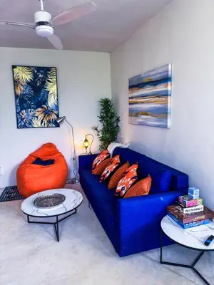 a living room with a blue couch and a table at Kaleidoscopic Apartment in La Majagua