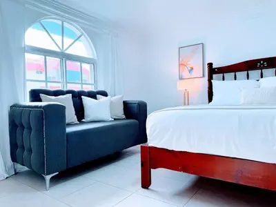 a bedroom with a bed and a blue couch at Rooftop, Pool View, Walk to Beach, Dining, Shops in Punta Cana