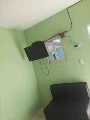 a green room with a window and a lamp on the wall at Una tarde trankilo in Sabana de Nisibón