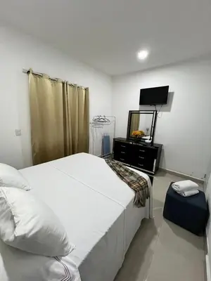 a bedroom with a white bed and a mirror at The Omelís House in Santa Bárbara de Samaná