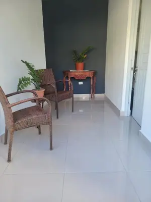 a hallway with wicker chairs and a table with potted plants at The Omelís House in Santa Bárbara de Samaná