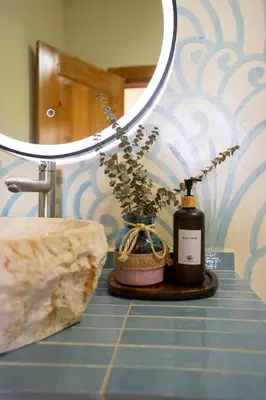 a bathroom counter with a bottle of perfume and a mirror at VillaVida Boutique Hotel - La Playita in Las Galeras