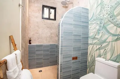 a bathroom with a shower with blue tile at VillaVida Boutique Hotel - La Playita in Las Galeras