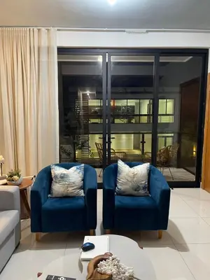 a living room with two blue chairs and a large window at modern y acogedor in San Felipe de Puerto Plata