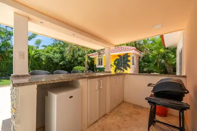 an outdoor kitchen with a bar and a grill at Casa Linda Villa 918 - Sosua in Sosúa