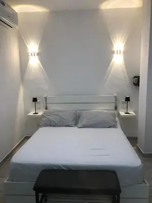 a bedroom with a bed with two lights on the wall at Bayahibe Apartments in Bayahibe