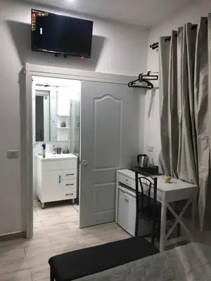 a bathroom with a sink and a television on the wall at Bayahibe Apartments in Bayahibe