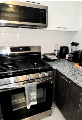 a kitchen with a stove and a microwave at Lindo 1BD apt in Bella Vista with Pool, Rooftop,Gym,Parking in Santo Domingo