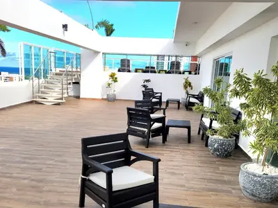 a row of black chairs in a room with windows at Lindo 1BD apt in Bella Vista with Pool, Rooftop,Gym,Parking in Santo Domingo