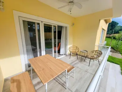 a patio with a wooden table and chairs at Lovely Condo in Gated Community in Sosúa