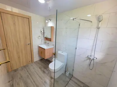 a bathroom with a toilet and a shower and a sink at Lovely Condo in Gated Community in Sosúa