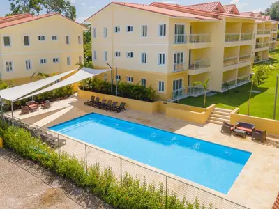 an image of a swimming pool in front of a building at Lovely Condo in Gated Community in Sosúa