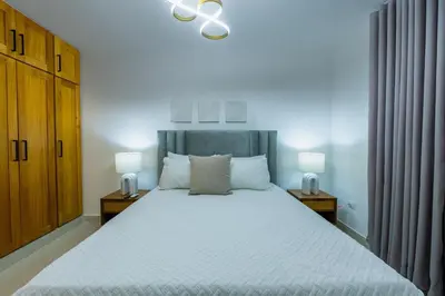 a bedroom with a large white bed with two lamps at Modern 3BR! 9fl, King Bed! Sti!, in Santiago de los Caballeros