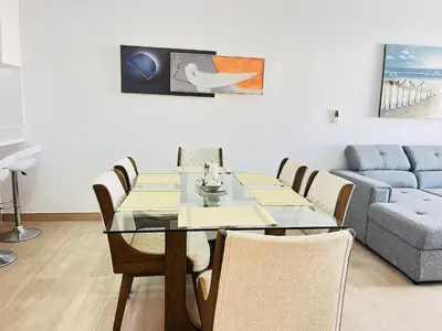 a dining room with a table and a couch at Dream pool views apartment close to the beach in Punta Cana