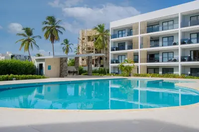 a swimming pool in front of a building at Dream pool views apartment close to the beach in Punta Cana