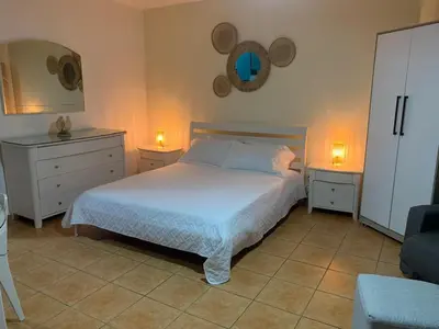 a bedroom with a bed with two nightstands and two lamps at Confortable vista al mar in Juan Dolio