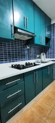 a kitchen with blue cabinets and a stove top oven at Confortable vista al mar in Juan Dolio