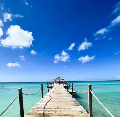 a wooden pier in the ocean with a blue sky at 2BR 2BA Beachfront 63 in Bayahibe