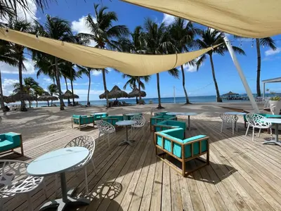 a deck with tables and chairs on a beach at 2BR 2BA Beachfront 63 in Bayahibe