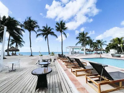 a resort with a pool and chairs and palm trees at 2BR 2BA Beachfront 63 in Bayahibe